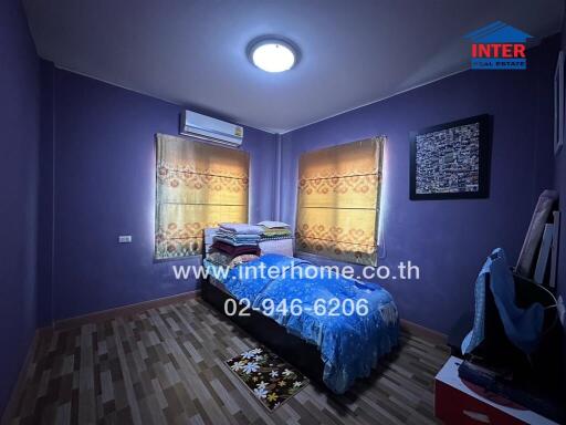 Cozy bedroom with wood floor and purple walls