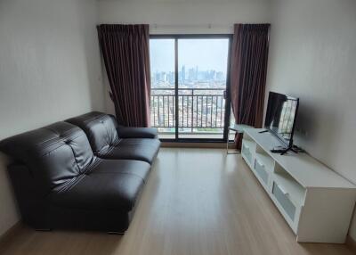 Modern living room with city view, leather sofa, and entertainment unit