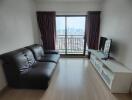 Modern living room with city view, leather sofa, and entertainment unit