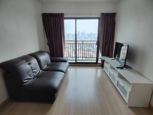 Modern living room with city view, leather sofa, and entertainment unit