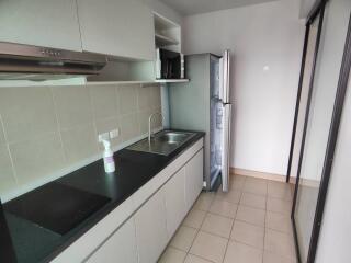 Modern kitchen with counter, sink, oven, and refrigerator