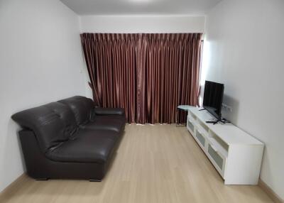 living room with sofa, TV, and curtains