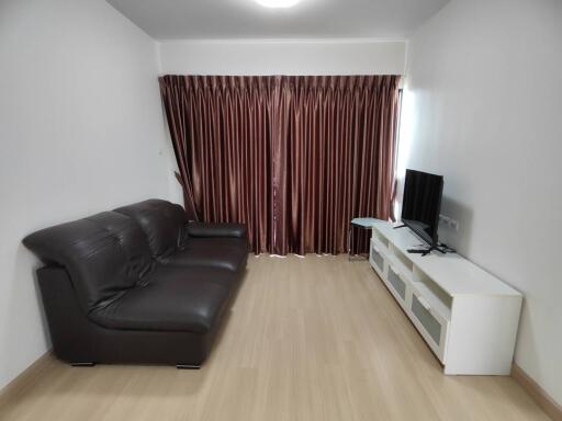 living room with sofa, TV, and curtains