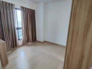 Empty bedroom with wooden floor and curtains