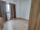 Empty bedroom with wooden floor and curtains