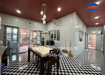 Spacious kitchen with checkered floor, white countertops, and dining table.