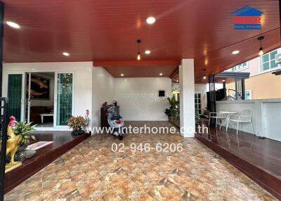 Outdoor view of the property showing a patio area with decorative plants, seating, and a tiled floor