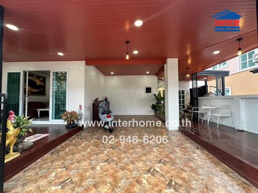 Outdoor view of the property showing a patio area with decorative plants, seating, and a tiled floor