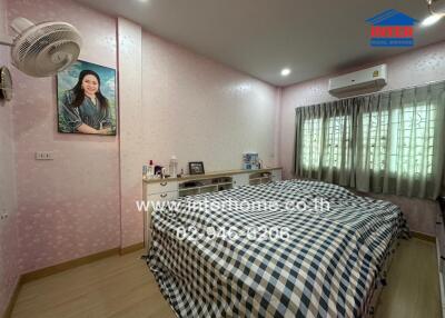 Bedroom with a double bed, checkered bedding, and pink wallpaper