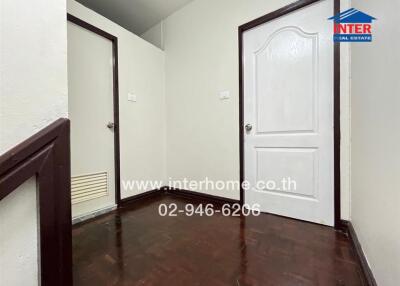 Hallway with dark wooden floor and two white doors