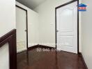 Hallway with dark wooden floor and two white doors