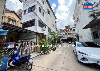 Exterior view showing multiple buildings, a car and motorbike parked in the driveway