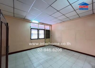 Empty room with tiled flooring and grid ceiling