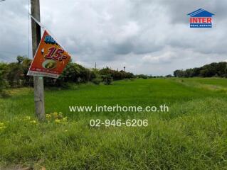 Open green field with advertisement board and contact information