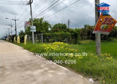 Street view near the property with visible greenery and road signs