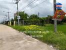 Street view near the property with visible greenery and road signs