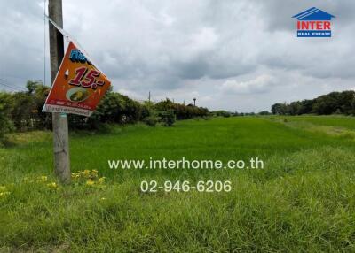 Open grass field with advertisement signs and contact details