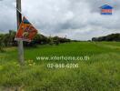 Open grass field with advertisement signs and contact details