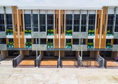 Modern multi-story building with balconies and parking spaces