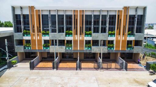 Modern multi-story building with balconies and parking spaces