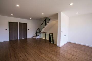 Spacious living area with wooden flooring and staircase