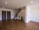 Spacious living area with wooden flooring and staircase