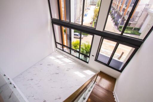 Spacious living area with large windows and staircase