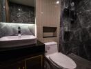 Modern bathroom with black marble tiles and standing shower