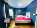 Cozy bedroom with blue walls, ceiling light, and wooden flooring