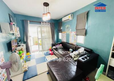 Cozy living room with blue walls, toys, and a dark sectional sofa.