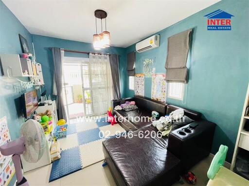 Cozy living room with blue walls, toys, and a dark sectional sofa.