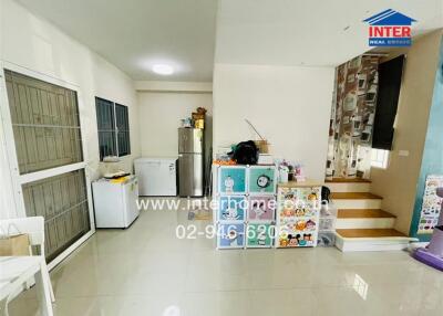 Compact kitchen and dining area with stairs leading up