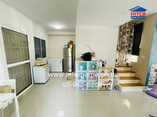 Compact kitchen and dining area with stairs leading up