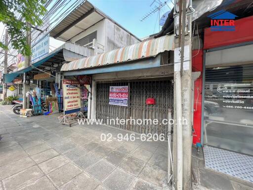 Exterior view of a commercial building with closed shutters and signage