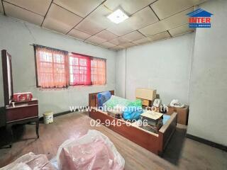 A disorganized bedroom with a bed, window, and scattered items.