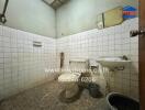 Bathroom with tiled walls, sink, toilet, and shower area