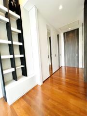 Well-lit hallway with wooden flooring and built-in shelving