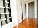 Well-lit hallway with wooden flooring and built-in shelving