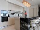 Modern kitchen with marble island and pendant lights