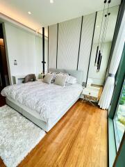 Modern bedroom with large window and hardwood floors