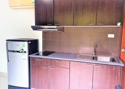 Modern kitchen with wooden cabinets, refrigerator, stove, and sink