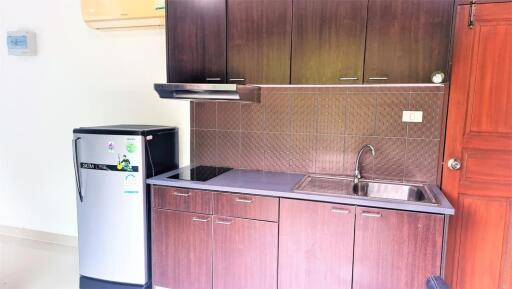 Modern kitchen with wooden cabinets, refrigerator, stove, and sink