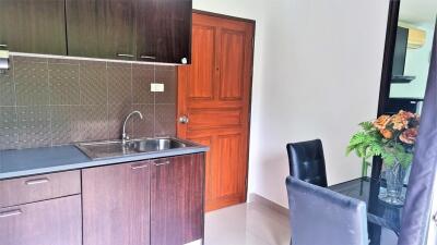 Modern kitchen with wooden cabinetry and dining area