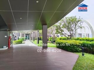 Outdoor walkway with garden and building in the background