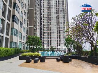 Outdoor view of a high-rise apartment building with a swimming pool and seating area