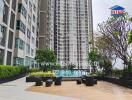 Outdoor view of a high-rise apartment building with a swimming pool and seating area