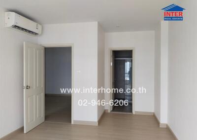 Spacious unfurnished bedroom with air conditioning and wooden flooring