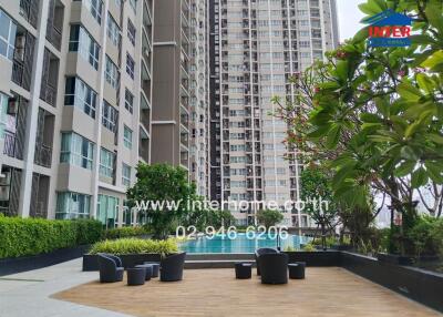 Outdoor patio and seating area with view of building and pool