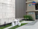 Outdoor seating area near a building with a small lawn and modern furniture