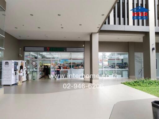 Entrance of a modern building with a convenience store